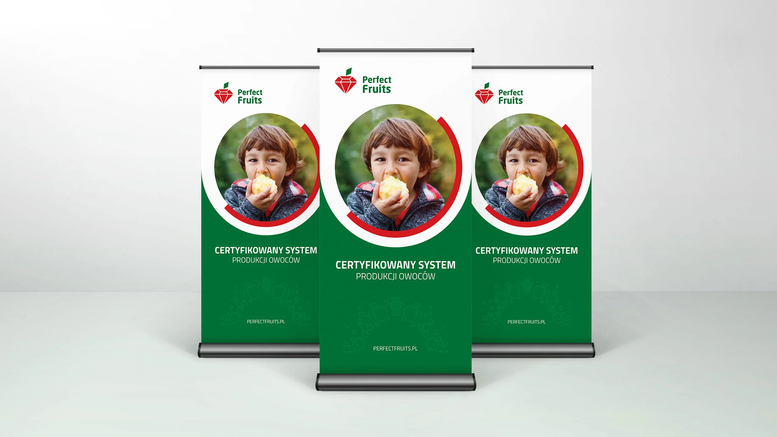 Roll up Perfect Fruits z hasłem „Certyfikowany system produkcji owoców” oraz zdjęciem dziecka jedzącego jabłko