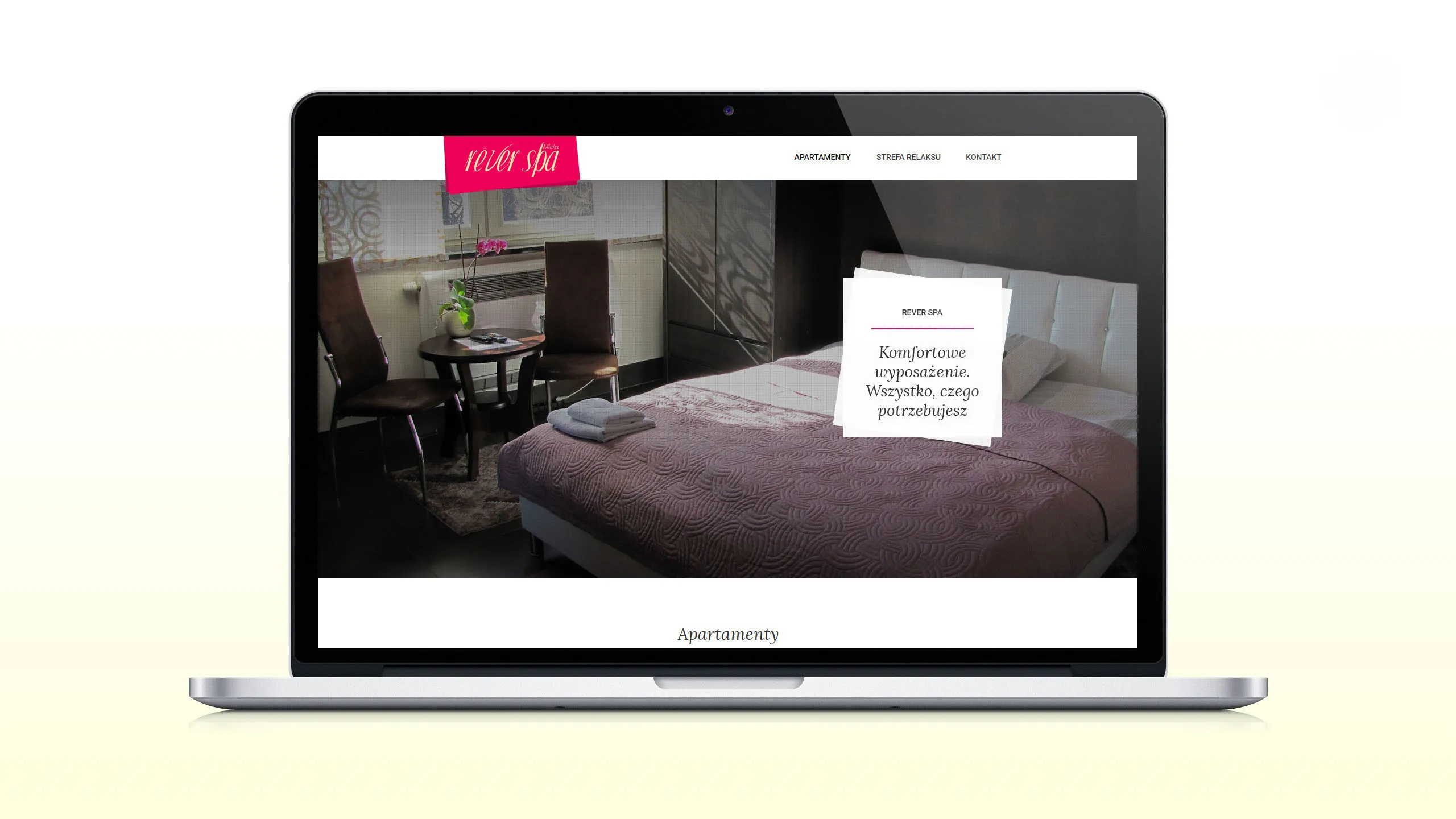 Strona internetowa Rever Spa wyświetlona na ekranie laptopa z widokiem apartamentu z łóżkiem i stolikiem